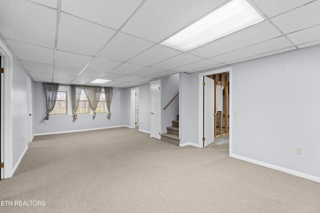 basement with a paneled ceiling and carpet floors