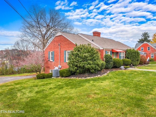 view of front of house featuring a front yard and central AC