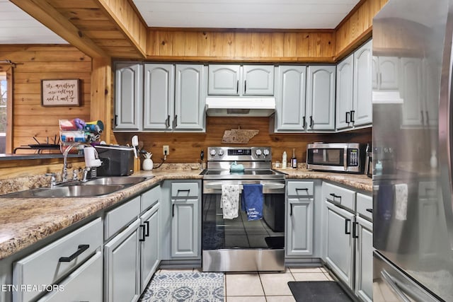 kitchen with appliances with stainless steel finishes, wooden ceiling, wood walls, and sink