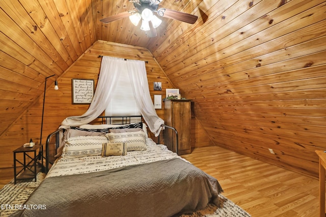 bedroom with wood ceiling, vaulted ceiling, ceiling fan, wooden walls, and hardwood / wood-style flooring