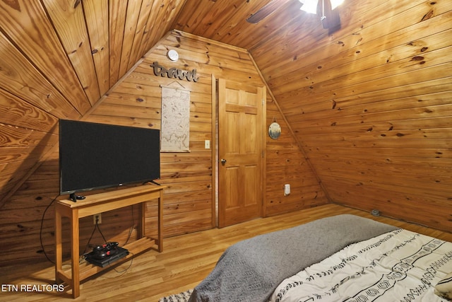 bedroom with lofted ceiling, wooden walls, ceiling fan, wood-type flooring, and wood ceiling