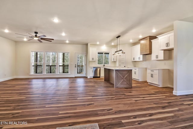 kitchen with white cabinetry, stainless steel dishwasher, decorative light fixtures, and a center island