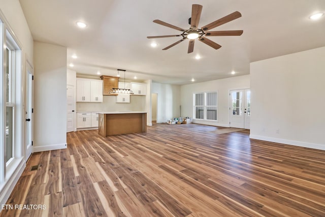 unfurnished living room featuring ceiling fan and dark hardwood / wood-style floors