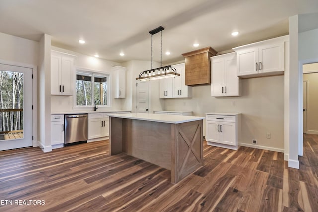 kitchen with decorative light fixtures, a kitchen island, stainless steel dishwasher, white cabinets, and dark hardwood / wood-style flooring