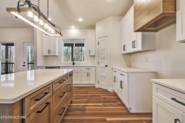 kitchen featuring decorative light fixtures, dark wood-type flooring, white cabinets, and a kitchen island