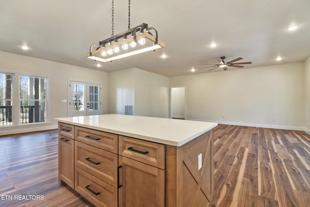 kitchen featuring ceiling fan, a center island, pendant lighting, french doors, and dark hardwood / wood-style flooring