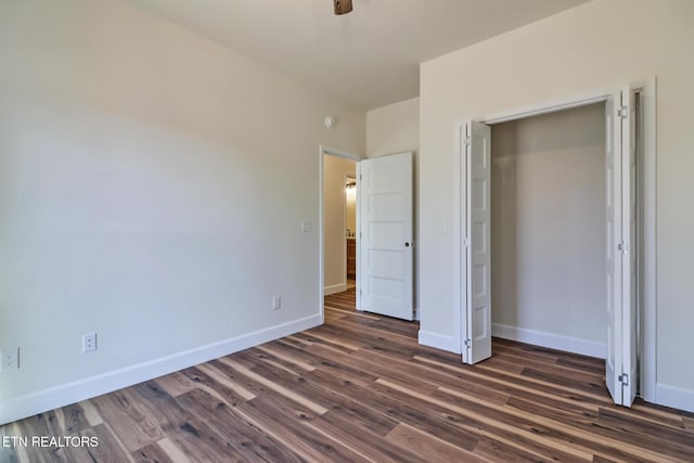 unfurnished bedroom with ceiling fan, a closet, and dark hardwood / wood-style floors