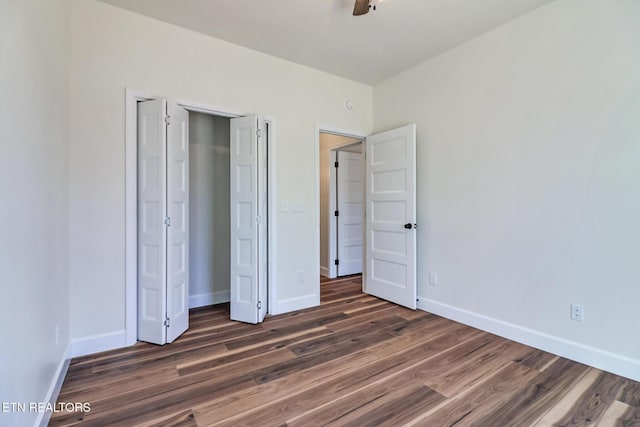 unfurnished bedroom featuring ceiling fan, dark hardwood / wood-style floors, and a closet