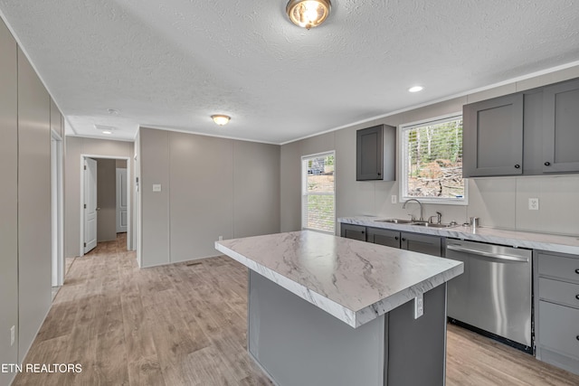 kitchen featuring dishwasher, sink, gray cabinets, light hardwood / wood-style floors, and a kitchen island