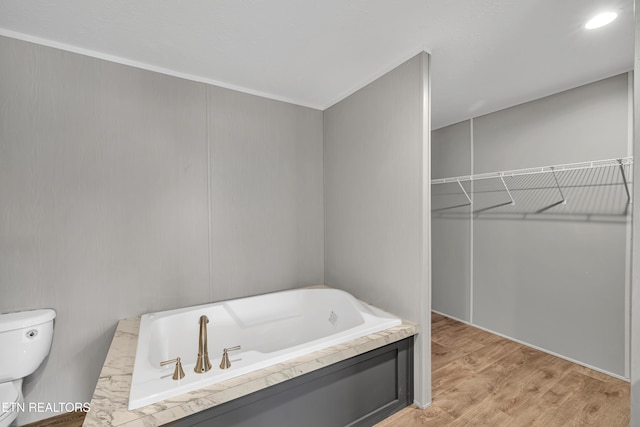 bathroom featuring hardwood / wood-style floors, a bathing tub, and toilet