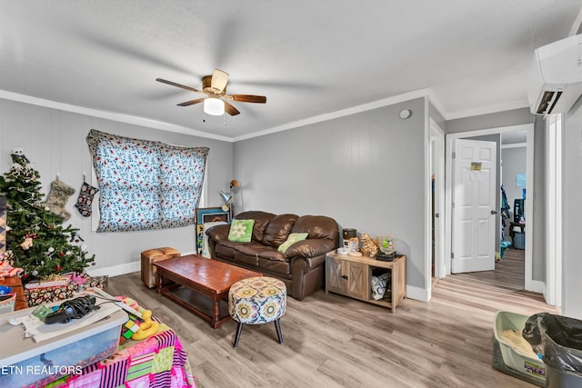 living room with a wall mounted air conditioner, crown molding, ceiling fan, light wood-type flooring, and a textured ceiling