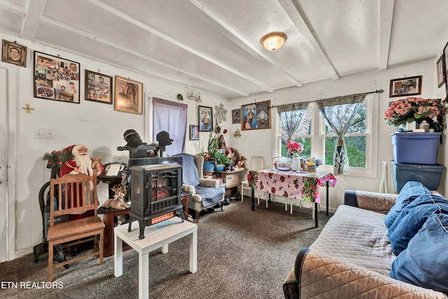 interior space with beam ceiling, a wood stove, and carpet floors