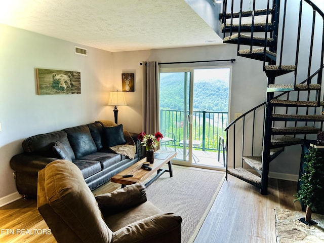 living room with wood-type flooring and a textured ceiling