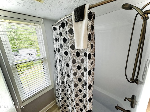 bathroom featuring shower / bath combination with curtain and a textured ceiling