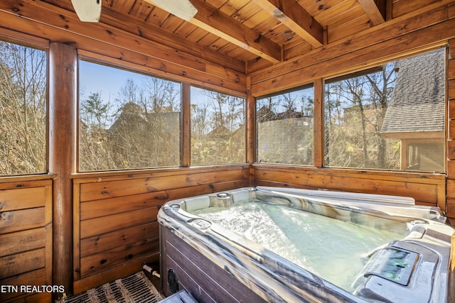 sunroom with beamed ceiling, a hot tub, and wooden ceiling