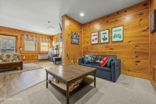 living room featuring wooden walls, light hardwood / wood-style floors, and a wall mounted air conditioner