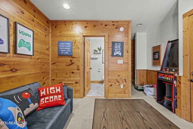 carpeted living room featuring wood walls