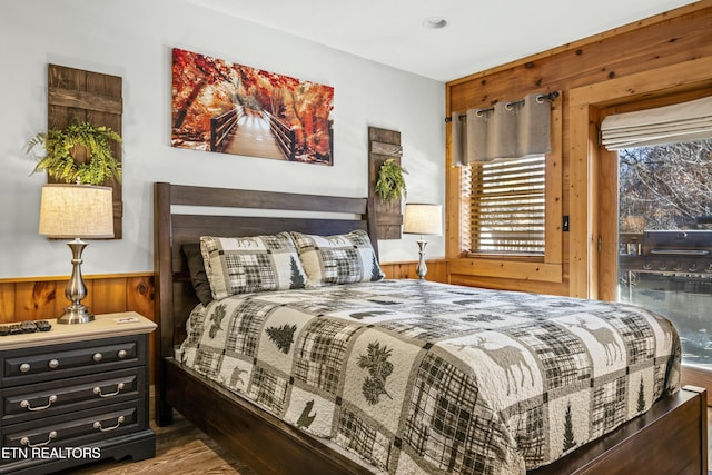 bedroom featuring wooden walls and hardwood / wood-style floors