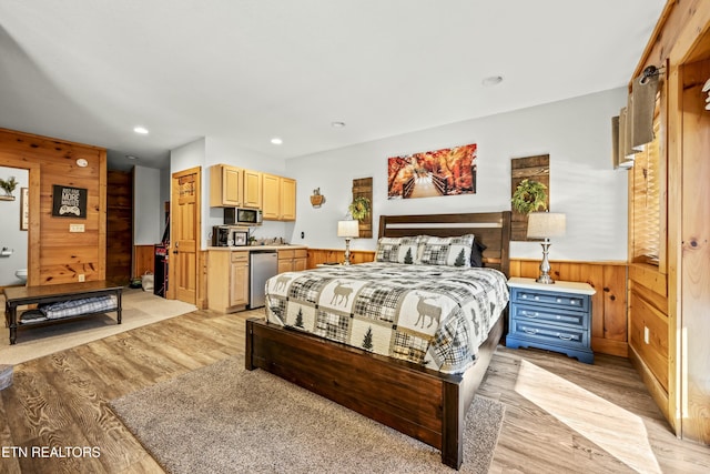 bedroom with stainless steel refrigerator, wooden walls, and light wood-type flooring