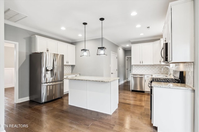 kitchen with decorative backsplash, stainless steel appliances, a kitchen island, and white cabinetry