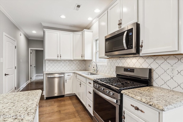 kitchen with white cabinetry, sink, light stone counters, and appliances with stainless steel finishes