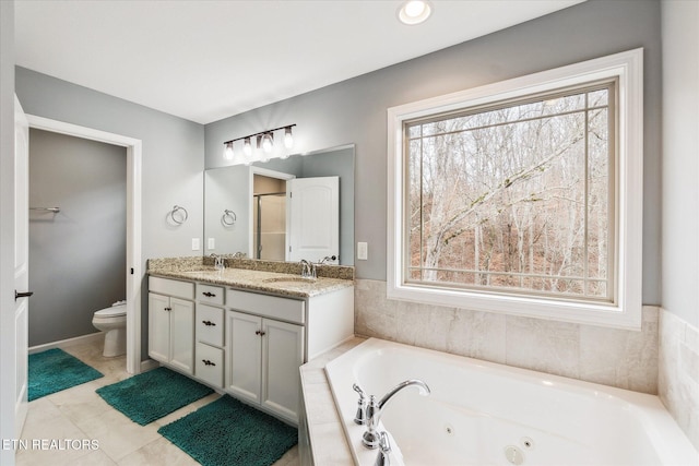 bathroom featuring tiled bath, tile patterned flooring, vanity, and toilet