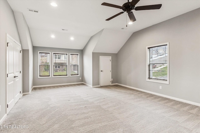 interior space with ceiling fan, light colored carpet, and lofted ceiling