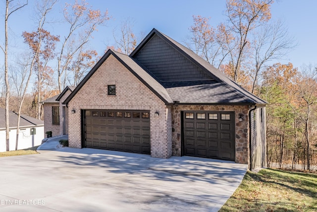 exterior space with stone siding, driveway, a garage, and roof with shingles