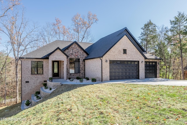 view of front facade with driveway, an attached garage, a shingled roof, a front lawn, and brick siding