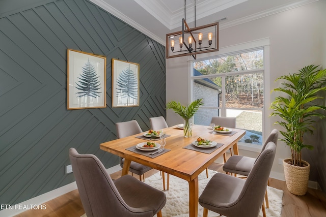 dining space featuring crown molding, a notable chandelier, wood finished floors, and baseboards