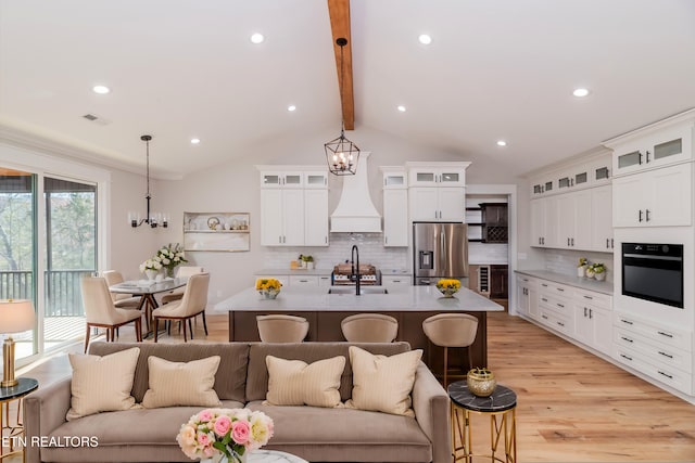 kitchen featuring a breakfast bar area, a sink, oven, stainless steel fridge, and open floor plan