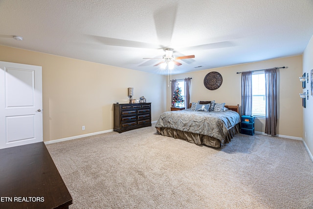 bedroom with ceiling fan, carpet, and a textured ceiling