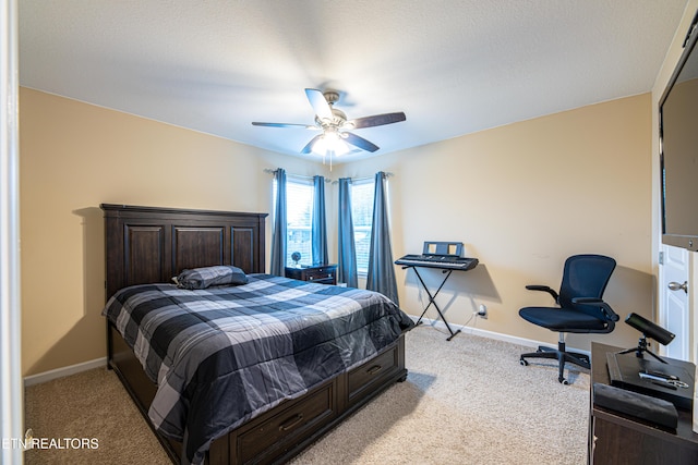 bedroom with a textured ceiling, light colored carpet, and ceiling fan