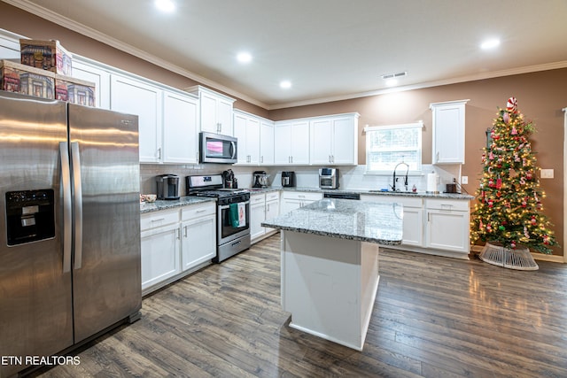 kitchen with white cabinets, dark hardwood / wood-style floors, light stone countertops, and appliances with stainless steel finishes