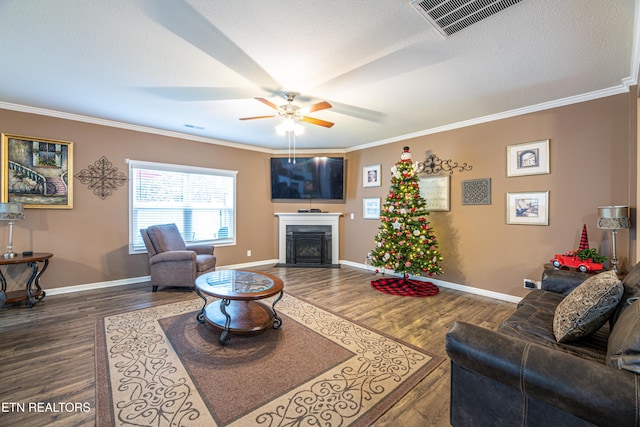 living room with a textured ceiling, ceiling fan, crown molding, and dark wood-type flooring