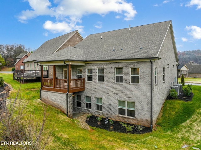 back of property with a yard and a wooden deck