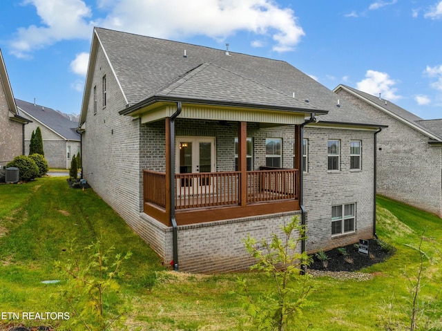 rear view of property with a yard and central AC