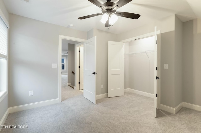 unfurnished bedroom with ceiling fan, light colored carpet, and a closet