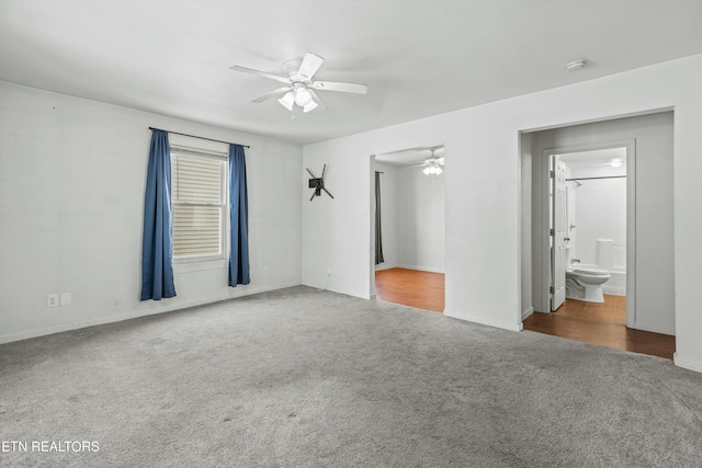 empty room featuring ceiling fan and dark carpet