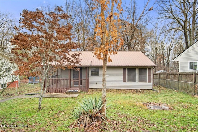 rear view of property featuring a yard and a sunroom