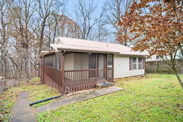 view of front of house featuring a sunroom and a front lawn