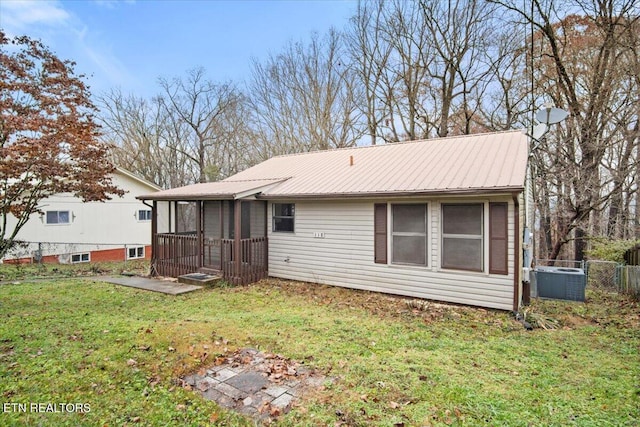 back of property featuring a lawn and a sunroom