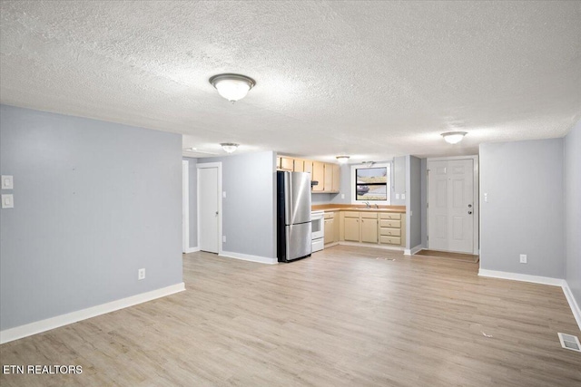 unfurnished living room featuring a textured ceiling and light wood-type flooring