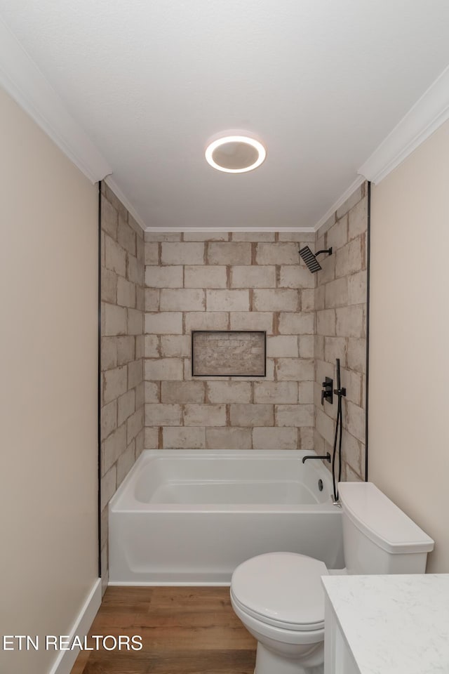 full bathroom featuring wood-type flooring, tiled shower / bath combo, toilet, and crown molding