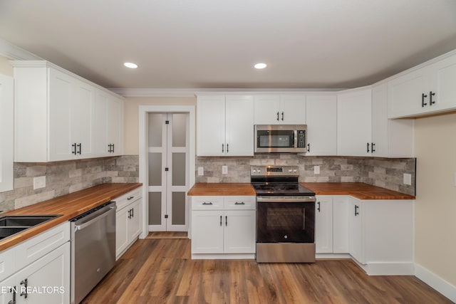 kitchen featuring white cabinetry, butcher block counters, and stainless steel appliances