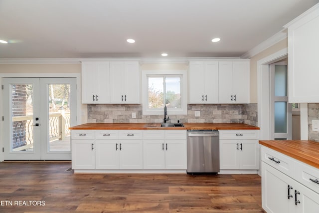 kitchen with wood counters, white cabinetry, stainless steel dishwasher, and sink