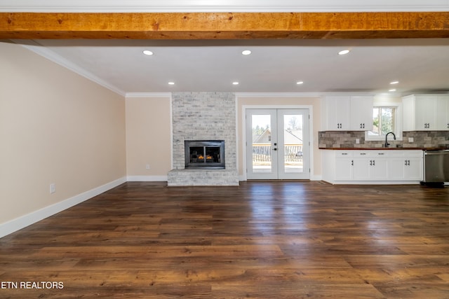 unfurnished living room with beamed ceiling, french doors, dark hardwood / wood-style floors, and crown molding