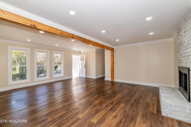 unfurnished living room with beamed ceiling, ornamental molding, dark wood-type flooring, and a brick fireplace