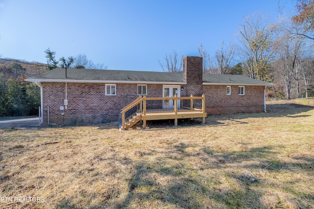 rear view of house featuring a lawn, french doors, and a deck