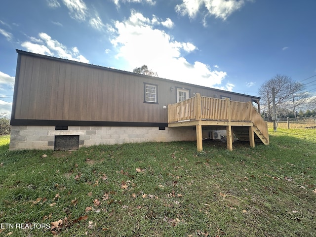 rear view of property featuring a lawn and a deck